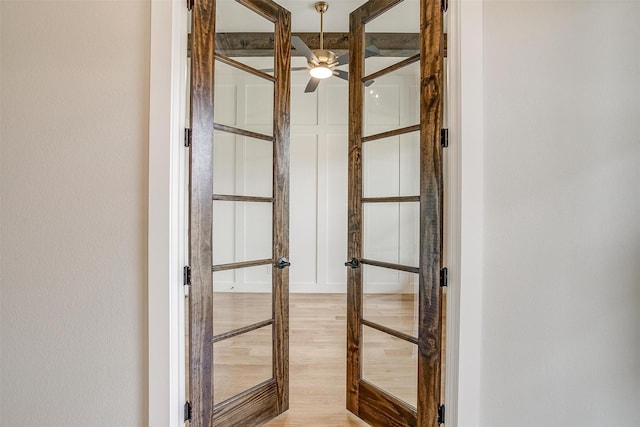 interior details featuring french doors, wood finished floors, and a ceiling fan