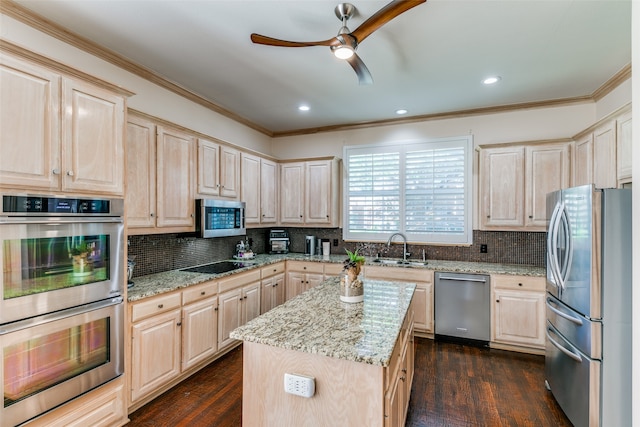 kitchen featuring a center island, sink, dark hardwood / wood-style floors, light stone countertops, and appliances with stainless steel finishes