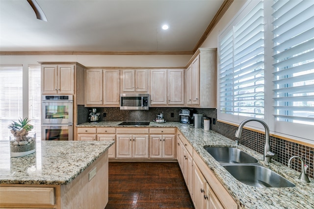 kitchen featuring stainless steel appliances, tasteful backsplash, light brown cabinetry, and sink