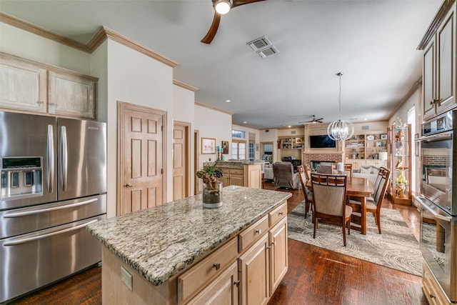 kitchen featuring a brick fireplace, dark wood-type flooring, appliances with stainless steel finishes, and a center island