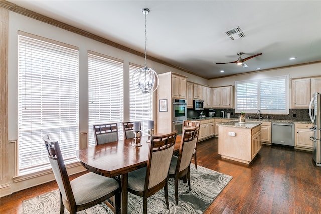 dining space with crown molding, sink, dark hardwood / wood-style floors, and ceiling fan with notable chandelier