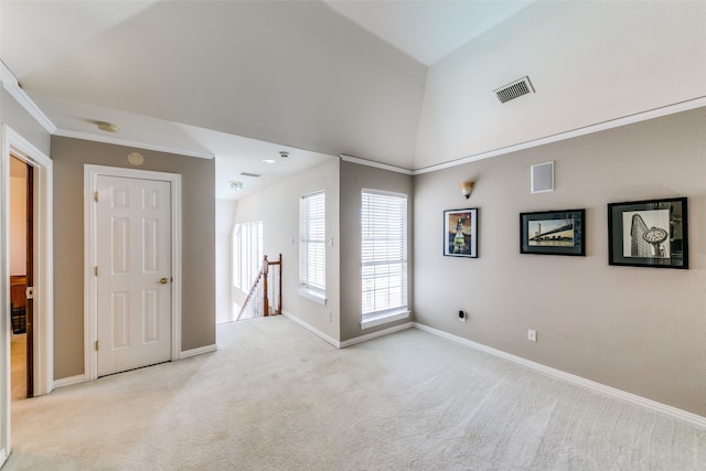 carpeted empty room featuring vaulted ceiling and ornamental molding