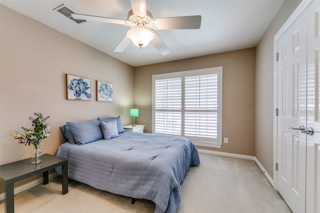 carpeted bedroom featuring ceiling fan and a closet