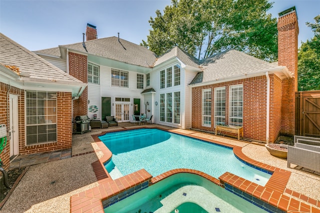 view of pool with a patio area, area for grilling, and an in ground hot tub