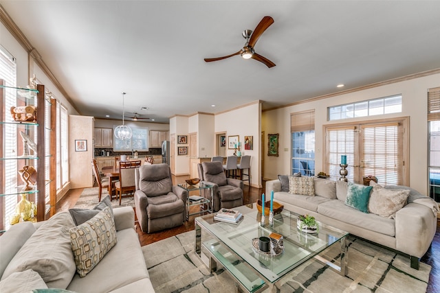 living room featuring ceiling fan, light wood-type flooring, and ornamental molding