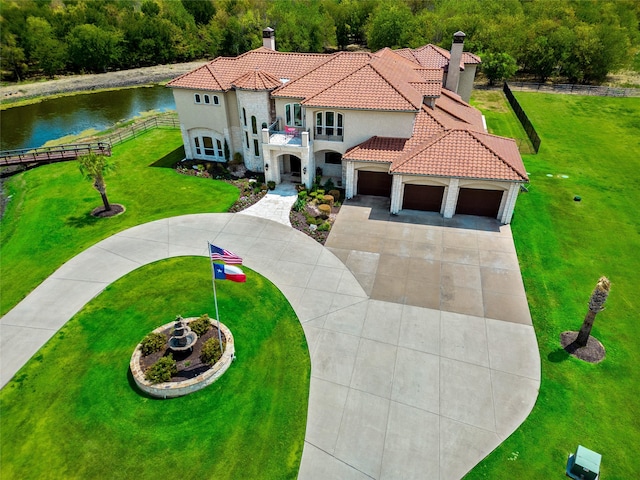 mediterranean / spanish house featuring a front lawn, a balcony, and a water view