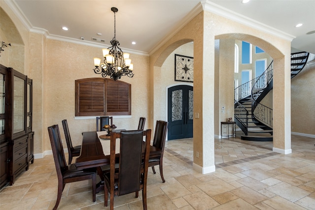 entrance foyer featuring a towering ceiling, ornamental molding, and french doors