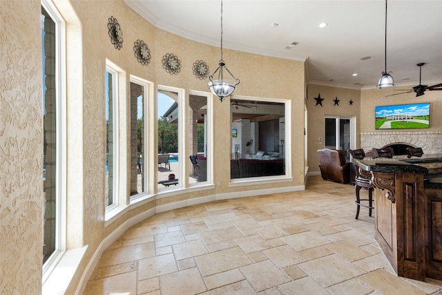 sunroom / solarium with plenty of natural light and ceiling fan with notable chandelier