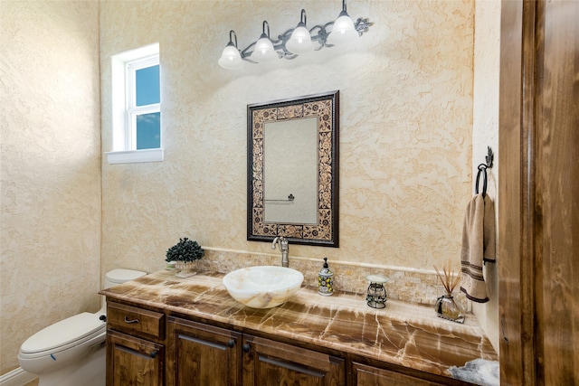 bathroom featuring vanity, toilet, a tile shower, and crown molding