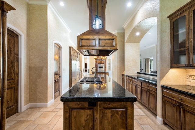 kitchen with appliances with stainless steel finishes, crown molding, sink, an inviting chandelier, and a kitchen island