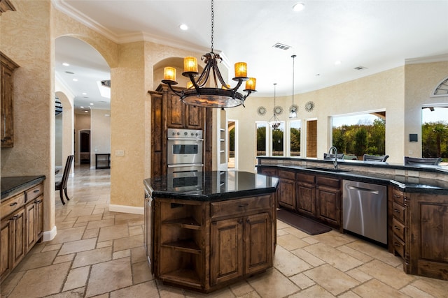 kitchen with an inviting chandelier, crown molding, sink, appliances with stainless steel finishes, and a kitchen island