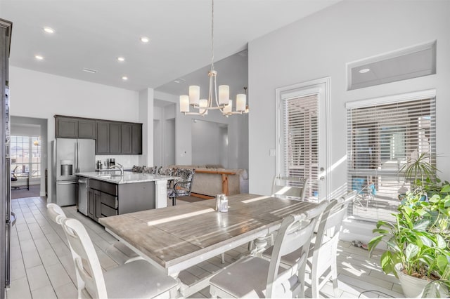 dining area with sink, light hardwood / wood-style flooring, and a notable chandelier