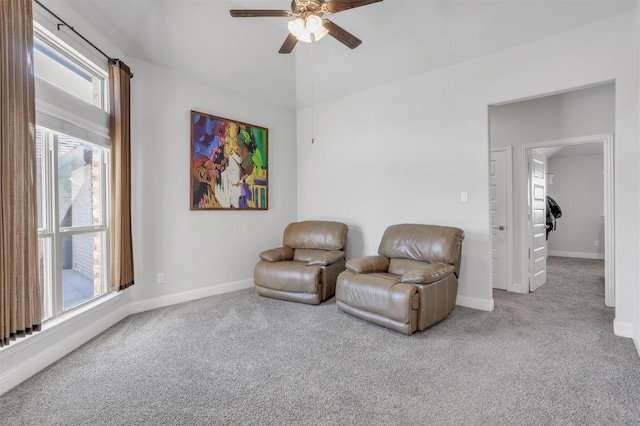 living area with light carpet and ceiling fan