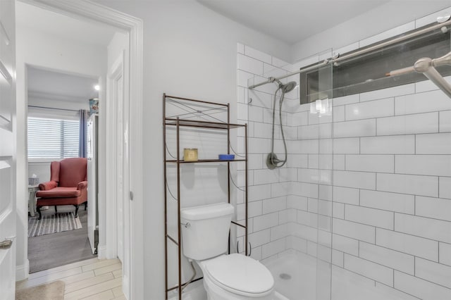 bathroom with toilet and a tile shower