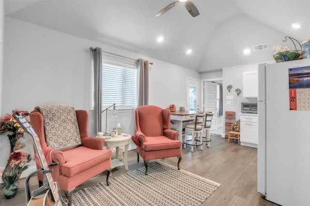 living area featuring ceiling fan, light hardwood / wood-style flooring, and high vaulted ceiling