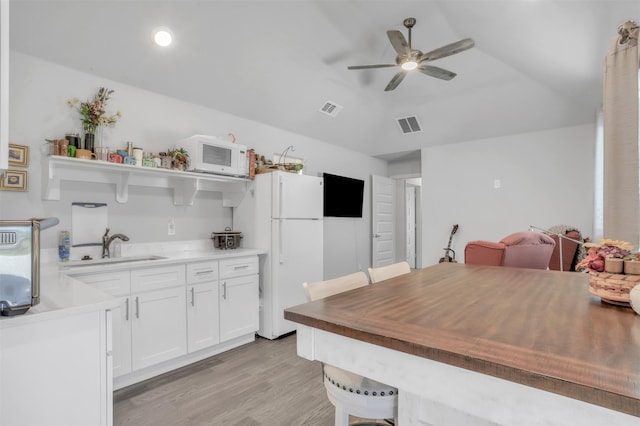 kitchen with ceiling fan, sink, white appliances, white cabinetry, and light hardwood / wood-style flooring