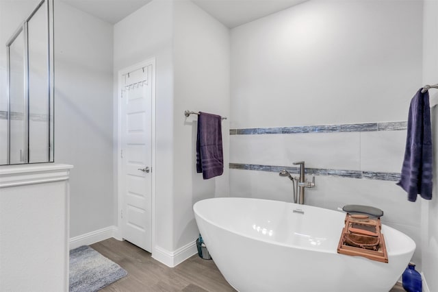 bathroom featuring hardwood / wood-style flooring and a bath