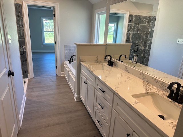 bathroom with hardwood / wood-style floors, vanity, and separate shower and tub