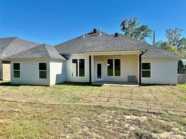 back of house with a lawn and a patio