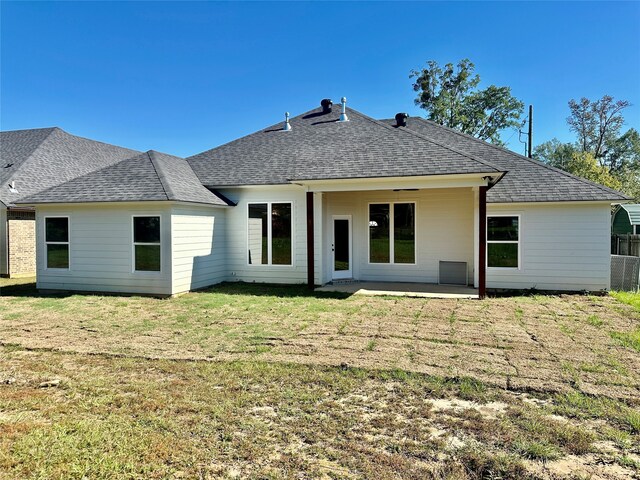 rear view of house featuring a lawn and a patio area