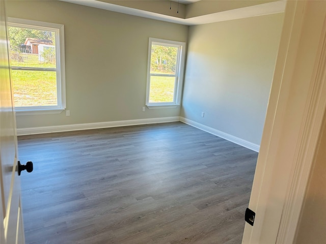 unfurnished room with a wealth of natural light, dark wood-type flooring, and ceiling fan