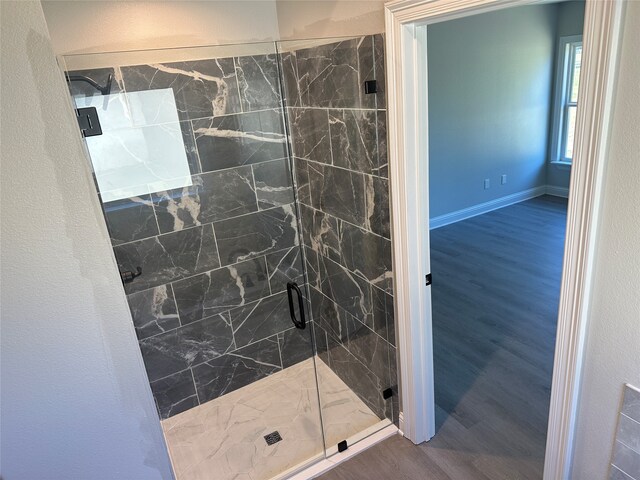 bathroom with hardwood / wood-style flooring and an enclosed shower