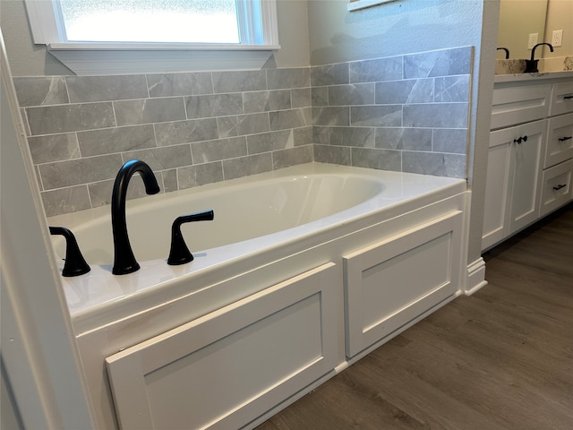 bathroom featuring hardwood / wood-style floors, vanity, and a bath