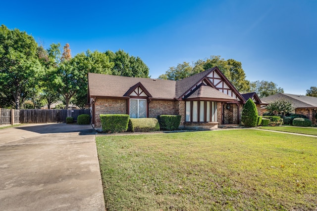 english style home featuring a front lawn