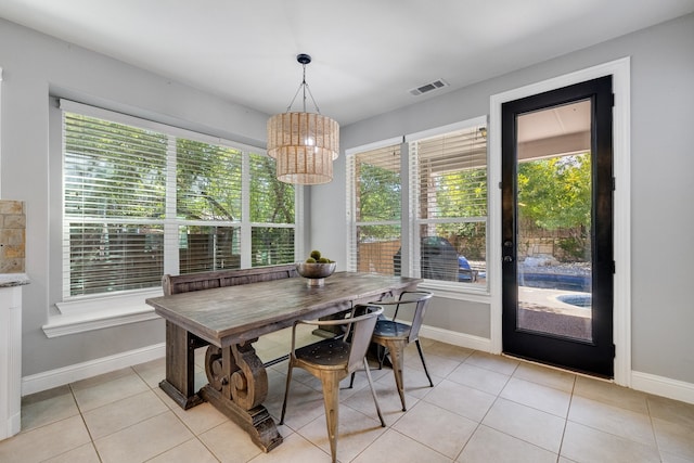 dining area featuring a notable chandelier and light tile patterned flooring