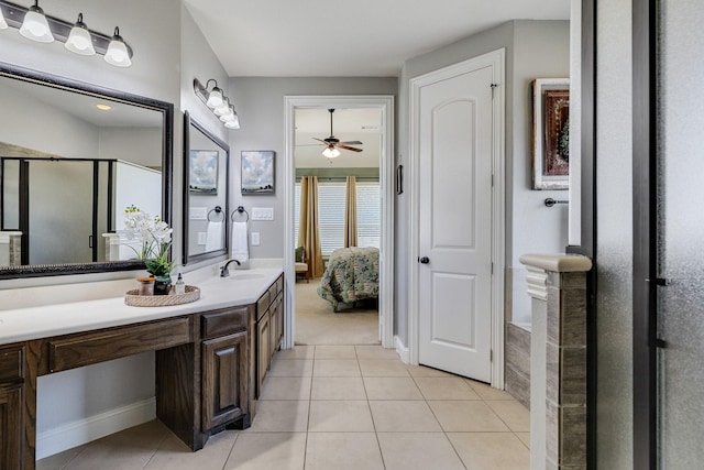 ensuite bathroom featuring a shower with door, connected bathroom, vanity, and tile patterned floors