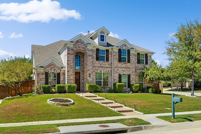 view of front of home with a front yard, brick siding, and fence