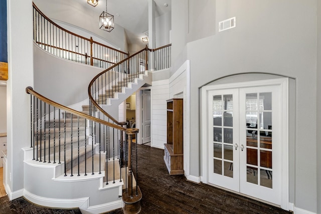 foyer entrance with french doors, visible vents, a high ceiling, wood finished floors, and baseboards