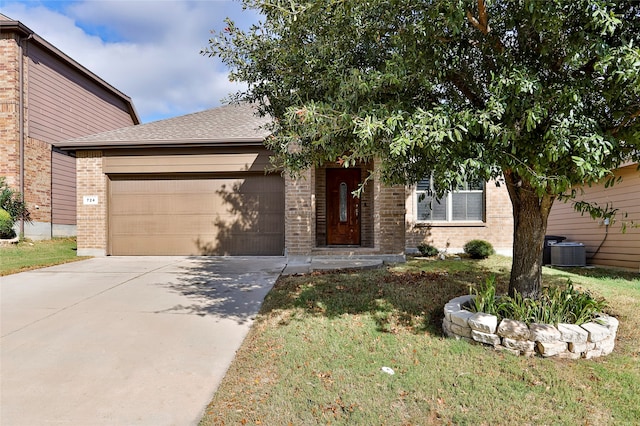 view of front of house featuring a garage, cooling unit, and a front lawn