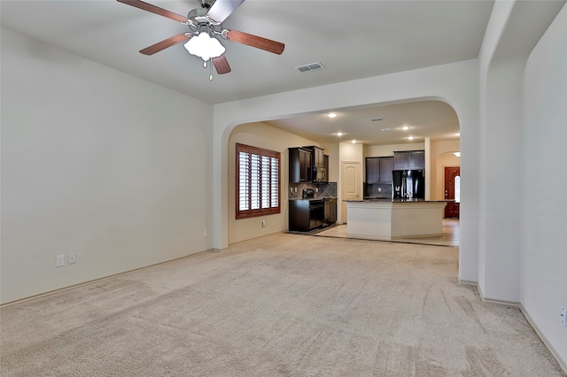 unfurnished living room with ceiling fan and light carpet