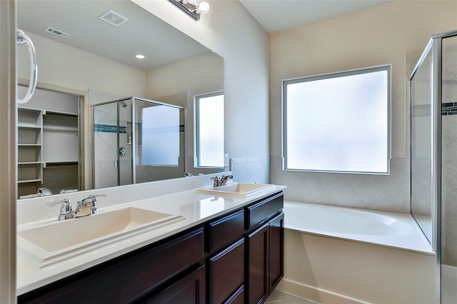 bathroom with tile patterned flooring, vanity, and independent shower and bath