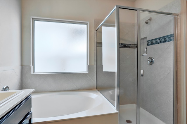 bathroom with vanity, shower with separate bathtub, and a wealth of natural light