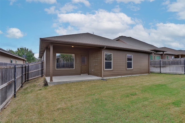 rear view of property with a patio and a lawn