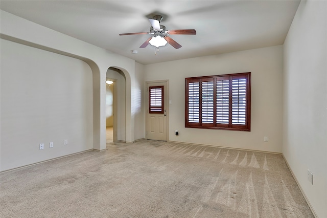 empty room with ceiling fan and light colored carpet