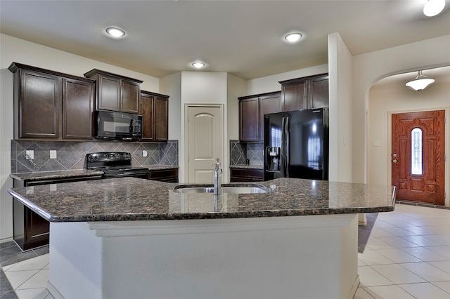 kitchen with black appliances, sink, an island with sink, and light tile patterned floors