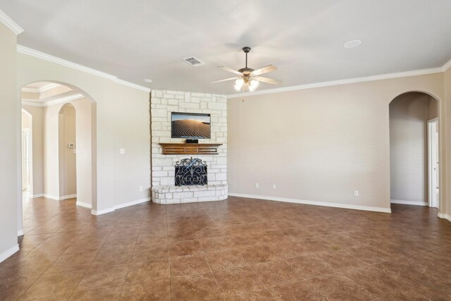 unfurnished living room featuring a stone fireplace, ceiling fan, and ornamental molding