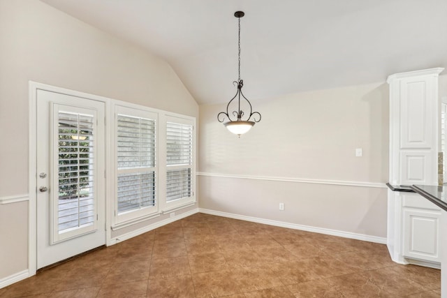 unfurnished dining area featuring light tile patterned floors and vaulted ceiling