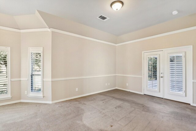 empty room with light colored carpet, crown molding, and french doors