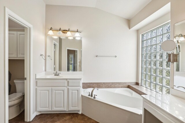 bathroom featuring a bathtub, vanity, lofted ceiling, and toilet