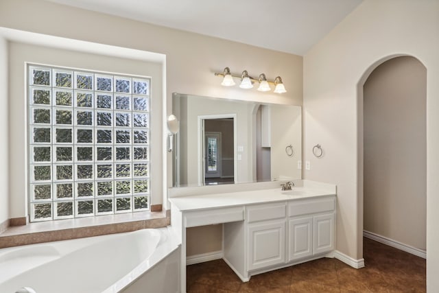 bathroom with tile patterned flooring, vanity, and a tub