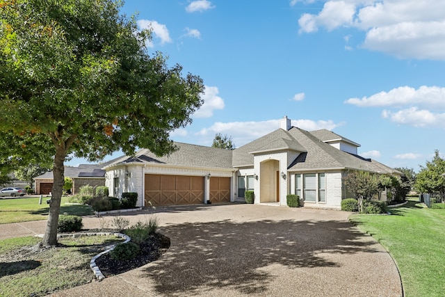 view of front of house with a garage and a front lawn