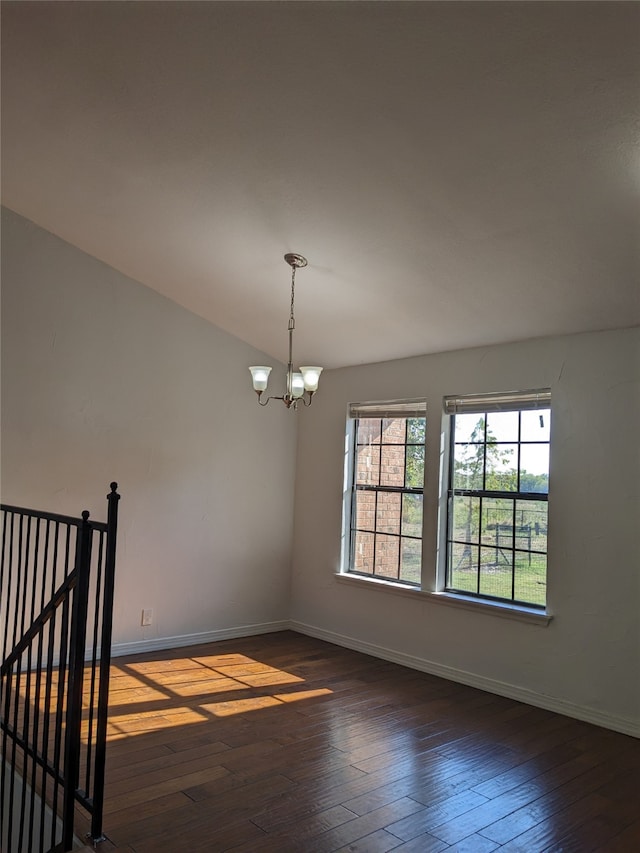 unfurnished room featuring dark wood-type flooring and a notable chandelier