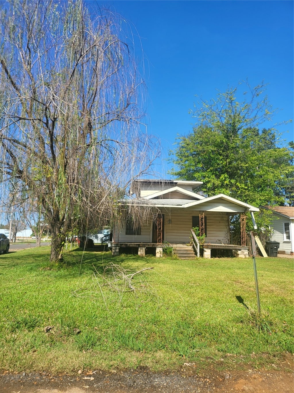 view of front of house with a front yard and covered porch