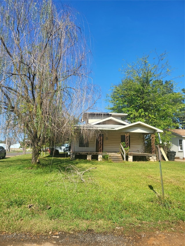 view of front of house with a front yard and covered porch