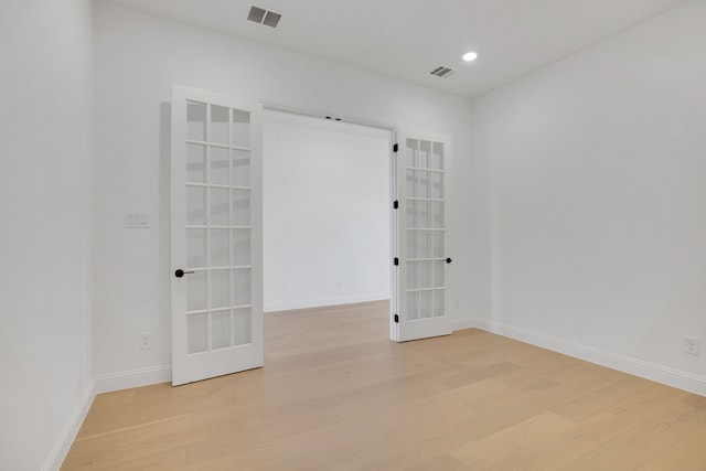 unfurnished room with french doors and light hardwood / wood-style flooring