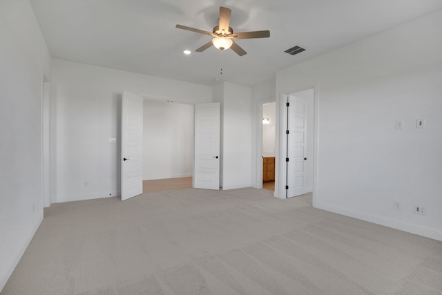 unfurnished bedroom with ensuite bath, ceiling fan, and light colored carpet